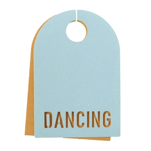 Détail d'une carte en papier bleu et orange avec texte DANCING ajouré et trou de suspension
