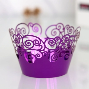 Detail of laser-cut scrollwork on purple pearlescent paper cupcake wrappers for parties
