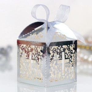 Detail of laser-cut silver mirror candy box with cross pattern and blue ribbon bow