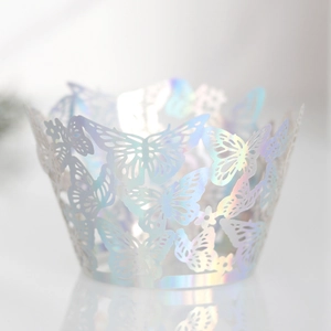 Detail of laser-cut iridescent white cupcake wrapper with elegant butterfly pattern