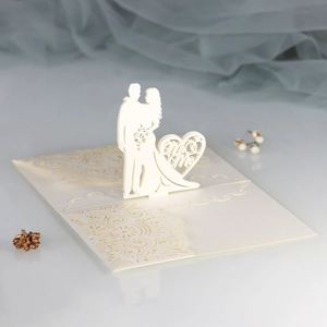 Macro shot of 3D laser-cut wedding invitation featuring Mr & Mrs heart silhouette and vines