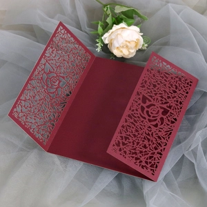 Detail of laser-cut rose patterns on elegant burgundy tri-fold wedding invitation card