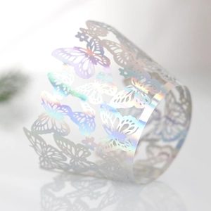 Macro view of laser-cut butterfly cupcake wrappers with iridescent holographic finish