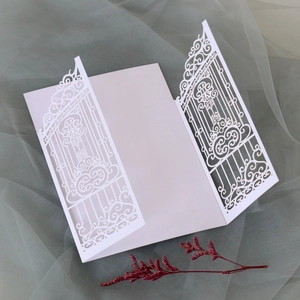 Macro detail of laser-cut gatefold wedding invitation with elegant floral lace patterns