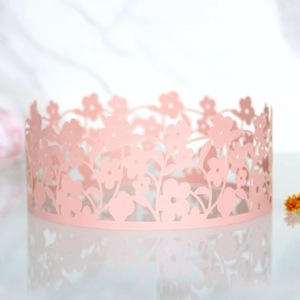 Close-up of pink laser-cut daisy flower lace borders for cake decorating and party decor