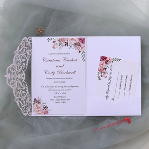 Detail of laser-cut lavender wedding invitation with floral card and RSVP on tulle