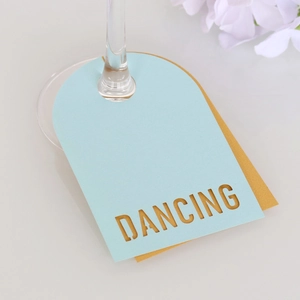 Vue détaillée des marque-places bleu clair et or pour verres à vin avec motif Dancing