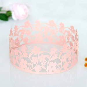 Detailed laser-cut pink flower crown cake wrap with elegant hollow floral pattern for party