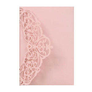 Detailed laser-cut pattern on light pink wedding invitation card with elegant symmetry