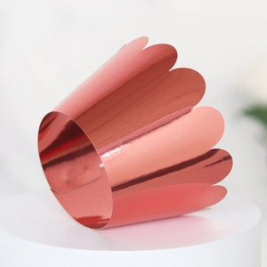 Detail of rose gold mirror cupcake wrapper with elegant laser-cut wavy edges for parties