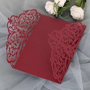 Detail view of burgundy laser-cut lace invitation card with elegant floral patterns