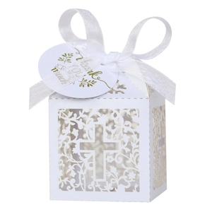 Detail of white laser-cut favor box with cross pattern, satin ribbon and Thank You tag
