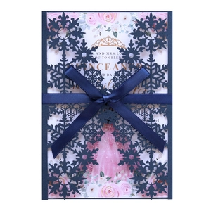 Winter laser-cut snowflake invitation set with navy blue ribbon and floral inner card