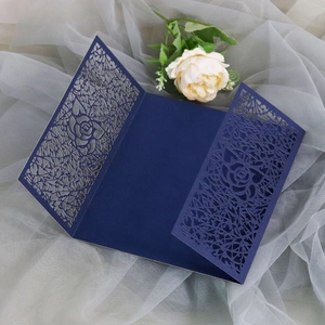 Detail of laser-cut rose patterns on elegant dark blue wedding invitation card cover
