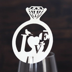 Macro view of white pearlescent paper wine glass card with diamond ring and LOVE design