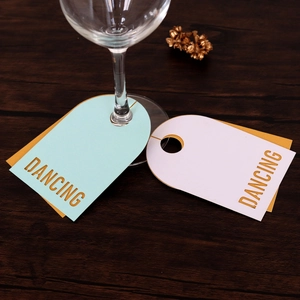Détail de marque-places bleus et blancs pour verres à vin sur une table en bois sombe
