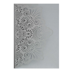 Detailed laser-cut mandala pattern on white pearlescent paper for wedding invitations