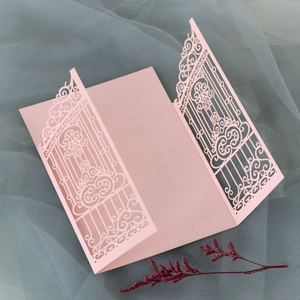 Macro shot of laser-cut pink gatefold invitation card with pearl paper texture