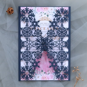 Macro view of navy blue laser-cut snowflake invitation with floral Quinceañera insert