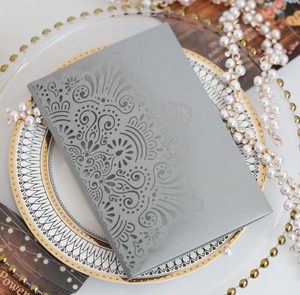 Detailed laser-cut hollow lace design on gray wedding invitation card with elegant texture