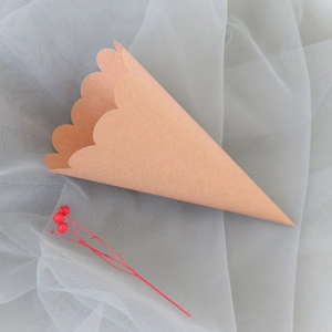 Close-up of brown kraft paper flower cone with scalloped wave edges for wedding petals