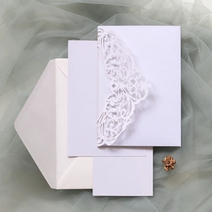 Detail of laser-cut wedding invitation featuring butterfly patterns and floral hollow designs