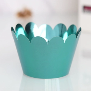 Macro view of metallic teal cupcake liner featuring decorative scalloped edges and glossy finish