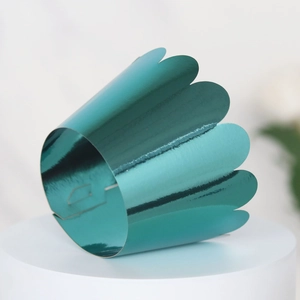 Laser-cut metallic teal cupcake wrapper with scalloped edges for birthday party decor