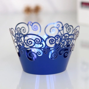 Detail of laser-cut jewel blue cupcake wrappers with elegant scroll pattern and pearl finish