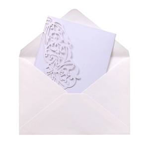 Detail of laser-cut white wedding invitation with intricate butterfly vine patterns and envelope