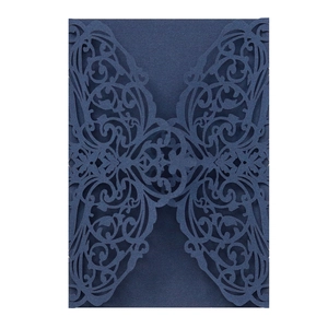 Macro detail of dark blue laser-cut wedding invitation card with intricate vine patterns