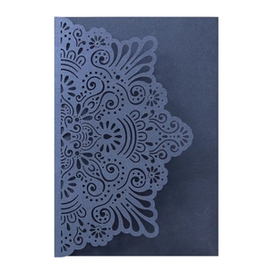 Macro detail of laser cut hollow design on dark blue pearlescent wedding invitation card