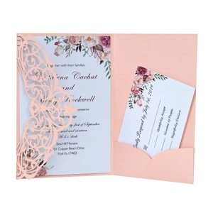 Close-up of pink laser-cut wedding invitation set with floral watercolor card and RSVP