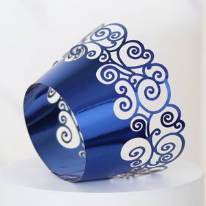 Detail of laser-cut blue mirror cupcake liners with decorative hollow cloud patterns