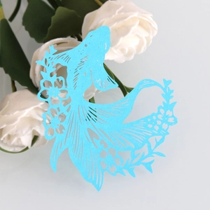 Detail of laser-cut blue cardstock koi fish card with intricate floral patterns