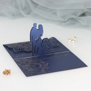 Detail of laser-cut pop-up wedding invitation featuring bride groom silhouette in navy blue