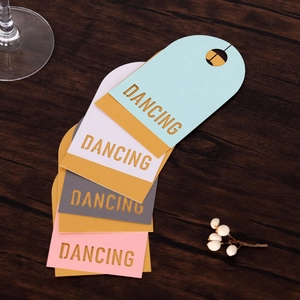 Gros plan de quatre marque-places colorés avec texte DANCING sur fond de bois