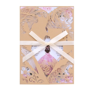 Detail of laser-cut kraft paper wedding invitation with floral patterns and silk ribbon