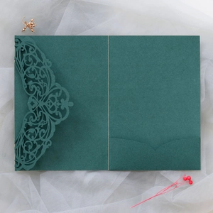 Detail of laser cut dark green invitation card with floral pattern and pocket