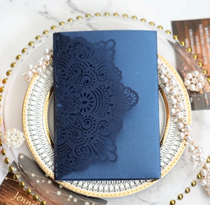 Detail of laser-cut navy wedding invitation with mandala pattern on elegant pearl paper