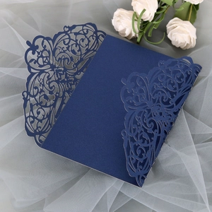 Detail of laser-cut navy blue lace invitation cover with elegant vine floral patterns