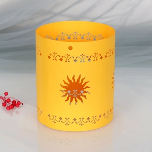 Detail of laser-cut paper lampshade featuring sun pattern and ornate scrollwork motifs