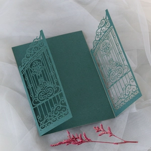 Detail of dark green laser cut gate wedding invitation with elegant hollowed pattern
