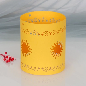 Detail of yellow paper lampshade featuring laser-cut sun patterns and scrollwork texture