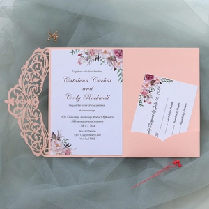 Detail view of pink laser cut wedding invitation with floral card and RSVP on mesh