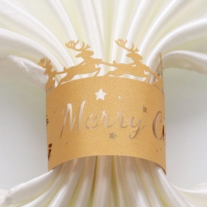 Detail of laser-cut gold glitter reindeer napkin ring with Merry Christmas text