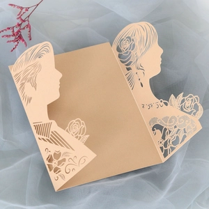 Macro shot of laser-cut rose lace wedding invitation with groom and bride silhouette