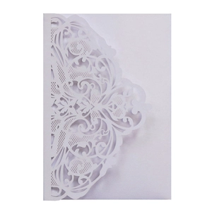 Close-up of laser-cut white cardstock with intricate floral lace for wedding invitations