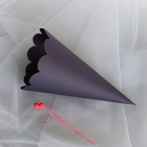 Close-up of deep purple paper cone with scalloped edges for wedding flower petals