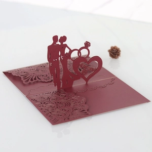 Detail of laser-cut wedding invitation featuring deep red 3D silhouettes and Mr & Mrs design